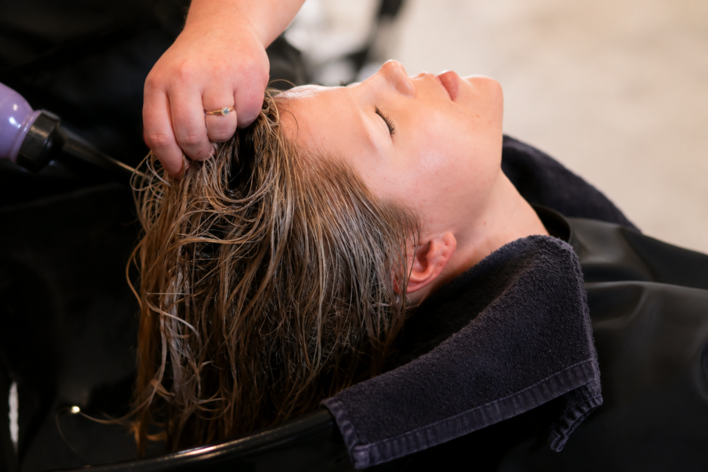 Woman washing hair with shampoo